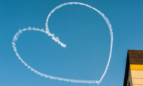 Low angle view of airplane flying against blue sky