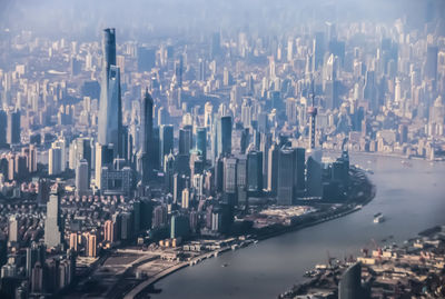 Aerial view of cityscape by sea against sky