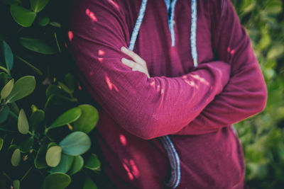 Midsection of man standing with arms crossed