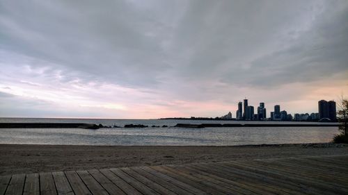 Scenic view of sea by buildings against sky