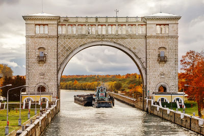 Bridge over river against cloudy sky