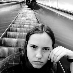 Portrait of woman sitting on escalator