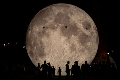 Group of people at concert against sky at night