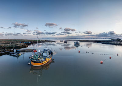 Boats moored in sea against sky