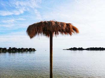 Straw beach umbrella in the middle of the sea