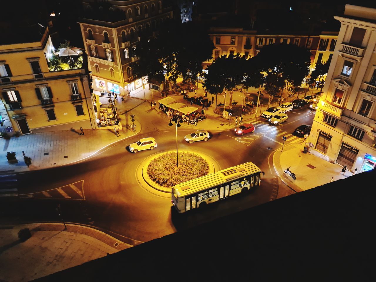 HIGH ANGLE VIEW OF ILLUMINATED STREET BY BUILDINGS IN CITY