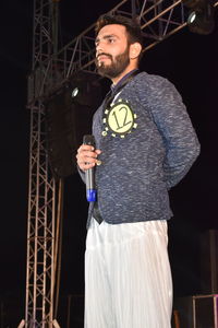 Man holding microphone while standing in music concert