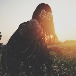 Close-up of young woman against clear sky during sunset