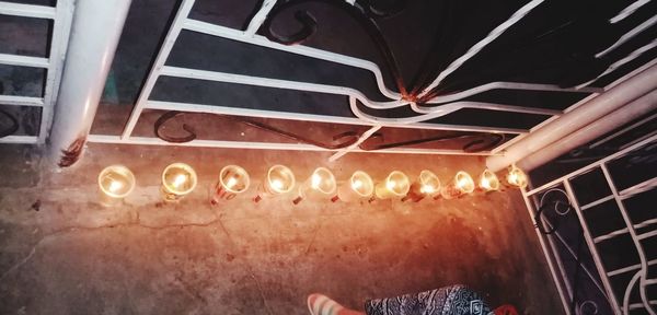 Low angle view of illuminated light bulbs hanging from ceiling