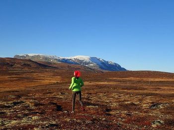 Full length of woman standing on mountain landscape