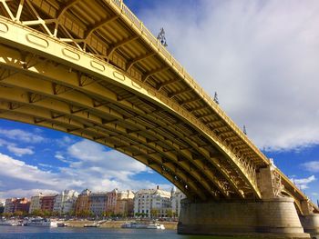 Low angle view of bridge over river against sky in city