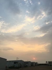 View of town against cloudy sky at sunset
