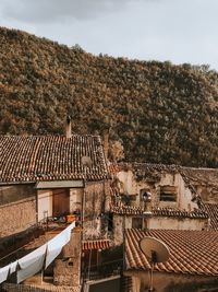 High angle view of old houses by mountain against sky