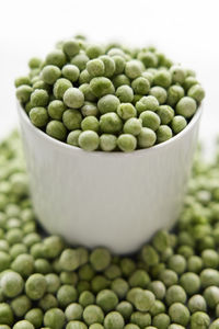 Green peas in bowl and on table