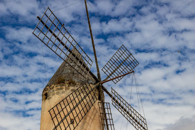 Windmill in palma on balearic island mallorca, spain on a sunny day with palm trees in front