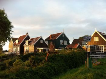 Dutch houses on field against sky