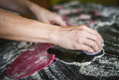 Cropped image of hand making cookies in kitchen