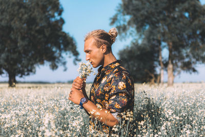 Side view of young woman looking away on field