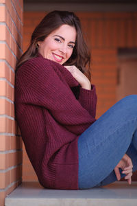 Portrait of a smiling young woman sitting outdoors