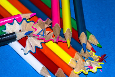 High angle view of colored pencils and shavings on table