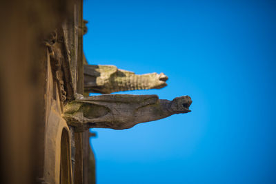 Low angle view of statue against blue sky