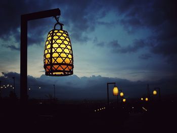 Illuminated lanterns hanging against sky at night