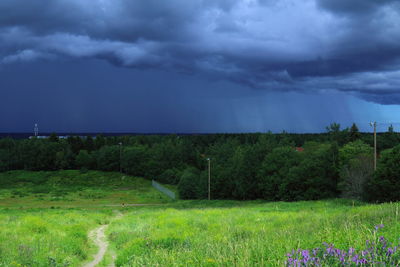 Scenic view of grassy field against cloudy sky