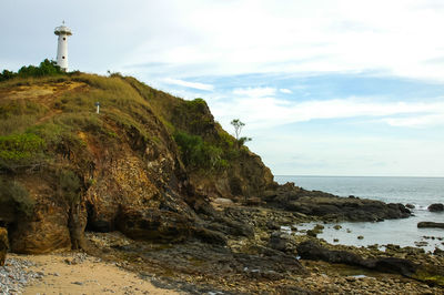 Rock formations by sea against sky