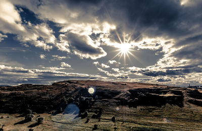 Scenic view of bright sun against sky during sunset