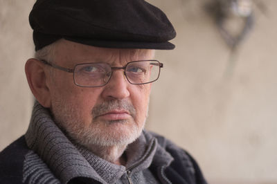 Close-up portrait of senior man wearing eyeglasses and cap