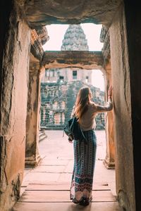 Rear view of woman standing in corridor of building