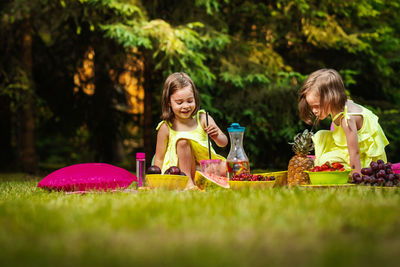 Cute siblings having food and drink in park