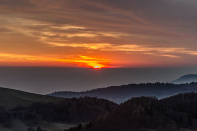 Scenic view of silhouette mountains against sky during sunset