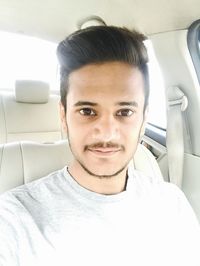 Portrait of smiling man sitting in car