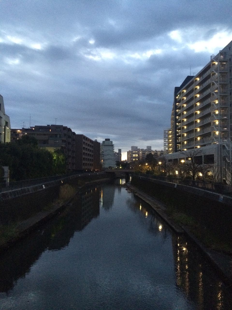 architecture, building exterior, built structure, city, water, sky, waterfront, reflection, river, cloud - sky, cityscape, residential building, building, cloudy, residential district, cloud, residential structure, canal, skyscraper, city life