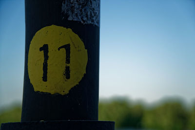 Close-up of road sign on wooden post