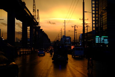 Cars on city street at sunset