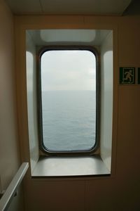 View of calm blue sea through window