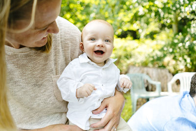 Closeup portrait of a baby boy laughing in his mom's arms