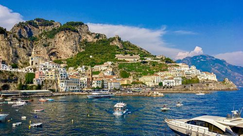 Scenic view of sea by buildings against sky