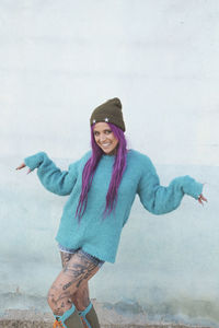 Portrait of smiling young woman standing in snow