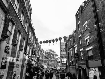 People walking on street amidst buildings in city