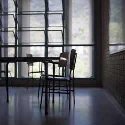 Empty chairs and table against window at home