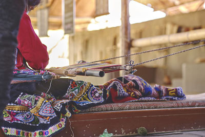 Indigenous woman showing traditional weaving technique and textile making in the andes mountain 