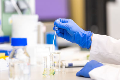 Midsection of scientist examining chemical in laboratory