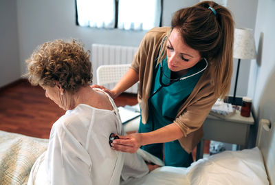 Female doctor examining woman at hospital