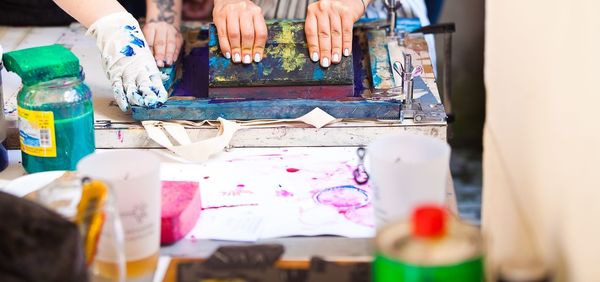 Cropped hands of people doing craft on table