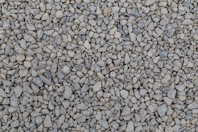 Dry white limestone ballast full frame background. small gray dusty broken macadam stones texture.