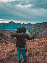 Rear view of man photographing against sky