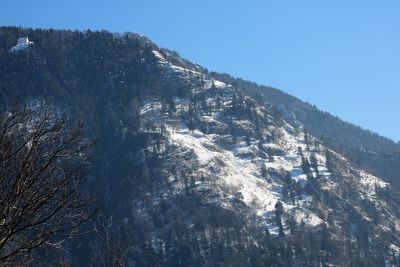 Low angle view of snowcapped mountains against clear sky